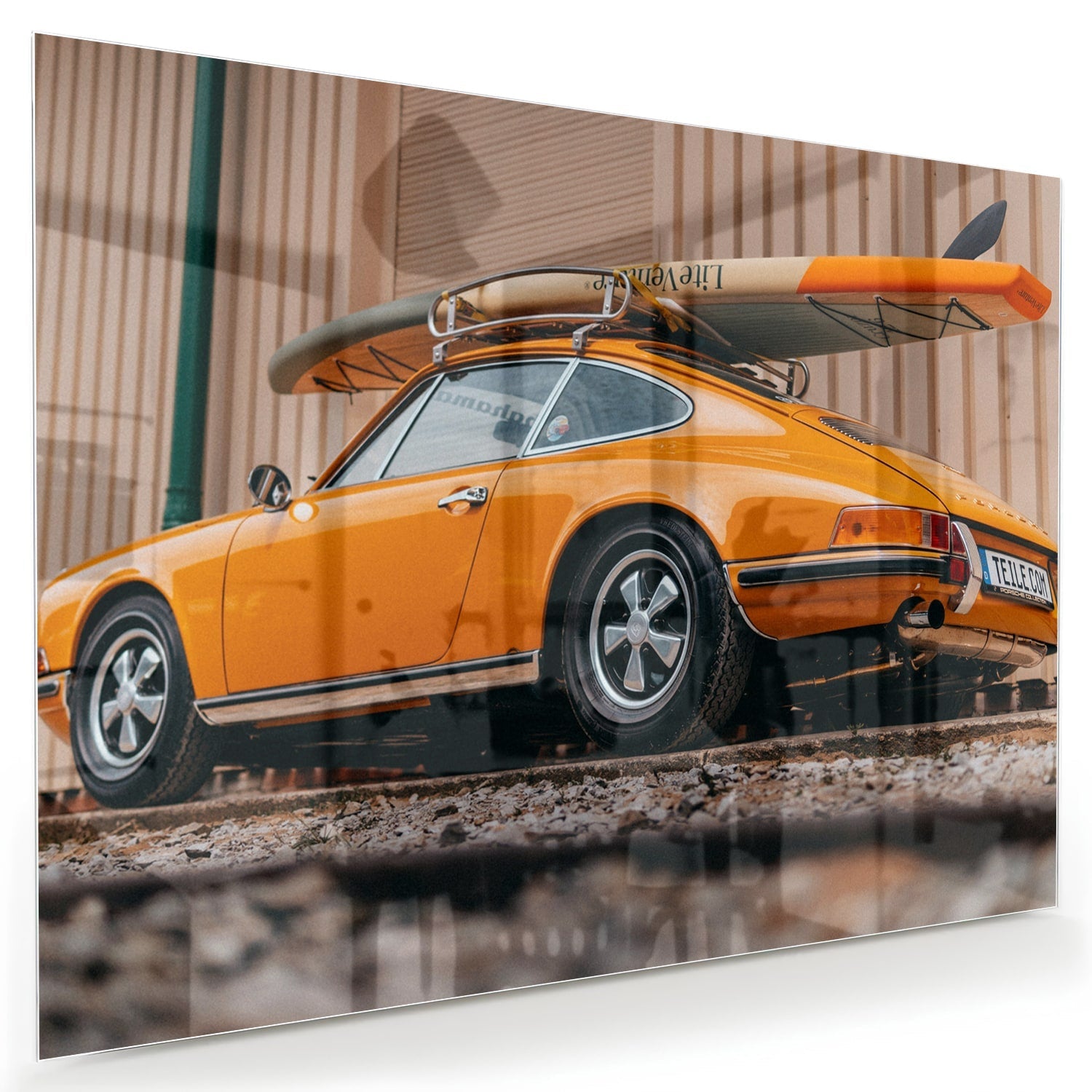 Leuchtendes Glasbild mit orangefarbenem Auto und Surfbrett